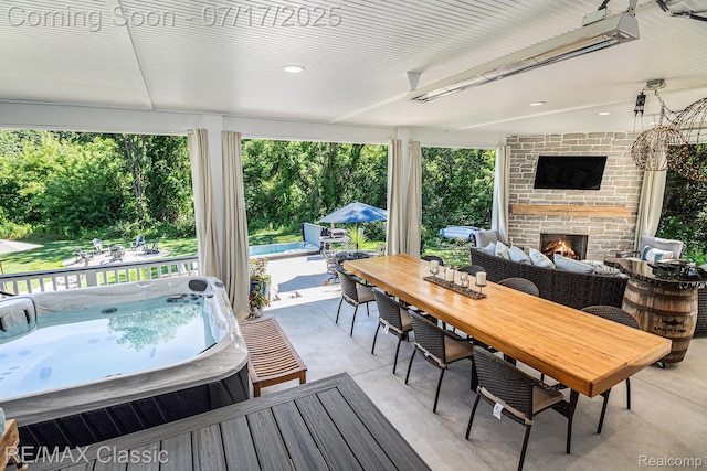 7171 Lucy Dr, Dexter, MI 48130 - deck with a fireplace, a hot tub, a patio, outdoor dining area, and an outdoor pool