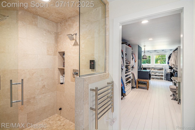 7171 Lucy Dr, Dexter, MI 48130 - bathroom with tiled shower, a spacious closet, recessed lighting, and wood finished floors