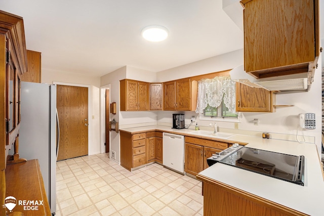 8208 E Potter Rd, Davison, MI 48423 - kitchen with white appliances, light countertops, brown cabinets, and light flooring
