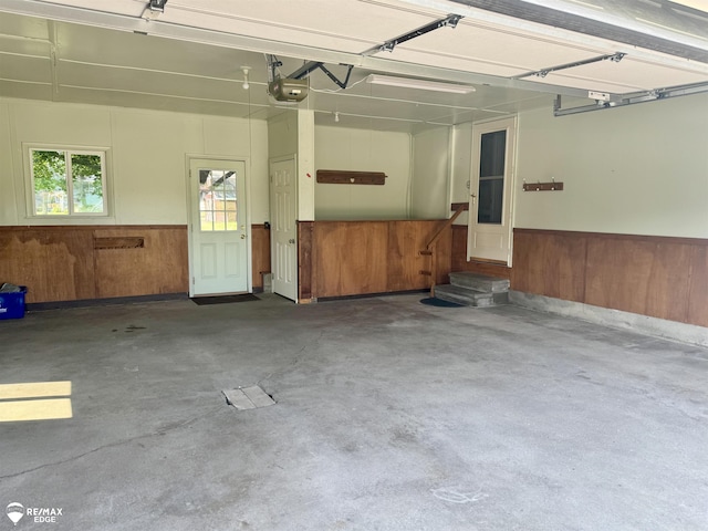 8208 E Potter Rd, Davison, MI 48423 - garage featuring a wainscoted wall, wood walls, and a garage door opener