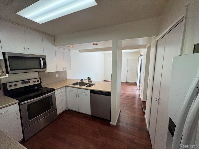 5216 Brett Ct, West Bloomfield, MI 48322 - kitchen featuring appliances with stainless steel finishes, dark wood-type flooring, light countertops, and white cabinetry