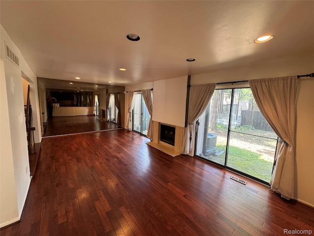 5216 Brett Ct, West Bloomfield, MI 48322 - unfurnished living room with a fireplace with raised hearth, dark wood-style flooring, plenty of natural light, and recessed lighting