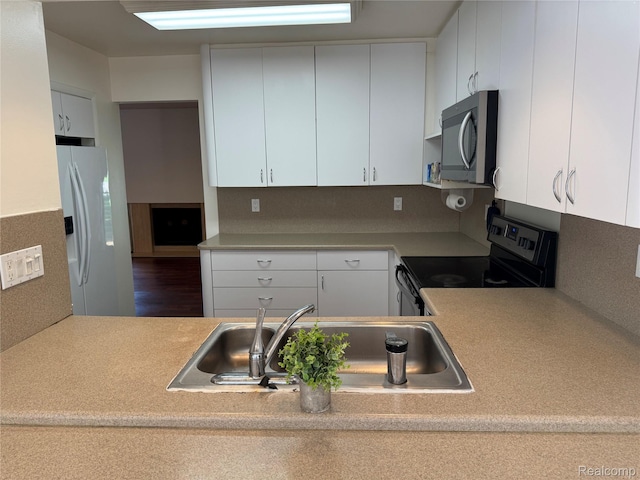 5216 Brett Ct, West Bloomfield, MI 48322 - kitchen with stainless steel microwave, black electric range, white refrigerator with ice dispenser, light countertops, and white cabinets