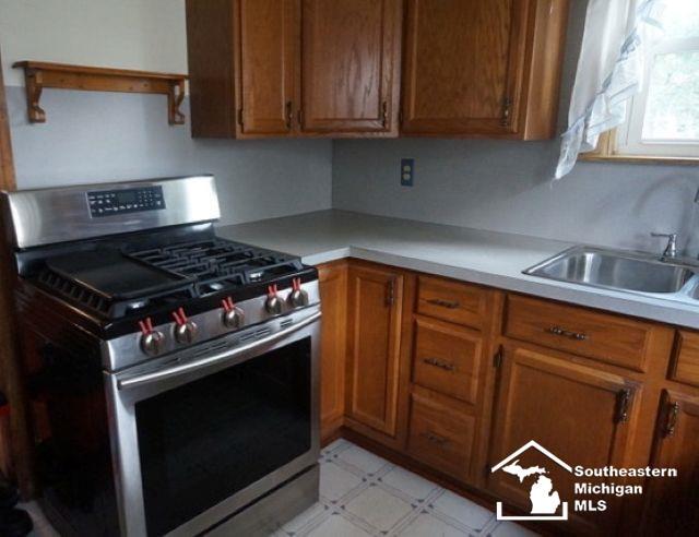 611 Hubble, Monroe, MI 48161 - kitchen with stainless steel gas range, brown cabinetry, light countertops, and light floors