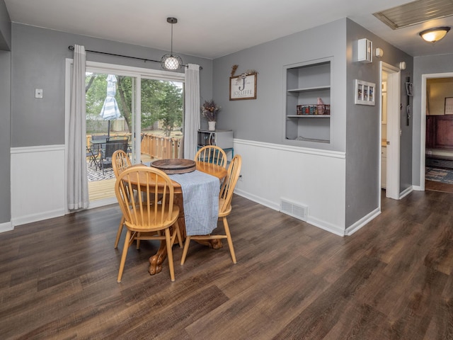 3130 27th St SW, Grandville, MI 49418 - dining area featuring built in shelves, a wainscoted wall, and wood finished floors