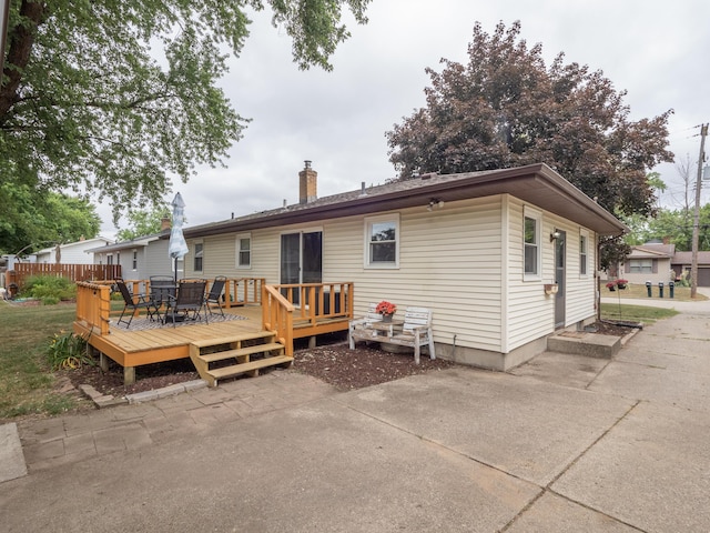 3130 27th St SW, Grandville, MI 49418 - back of property featuring a deck, a chimney, and outdoor dining area