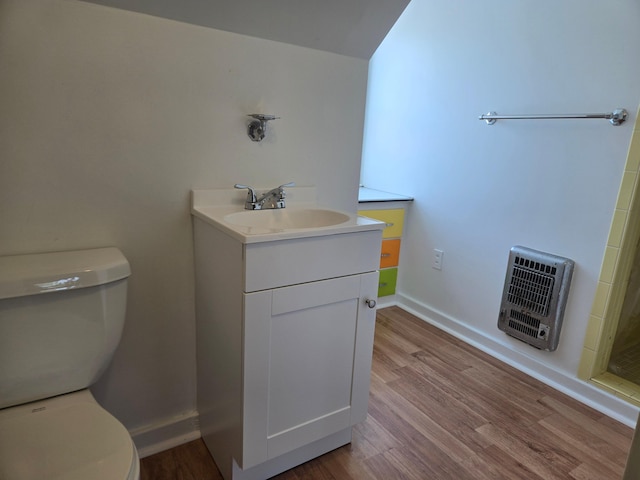 1115 W Maumee St, Adrian, MI 49221 - bathroom featuring heating unit, wood finished floors, and vanity