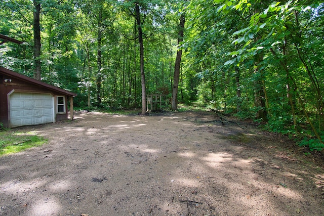 23627 Glenwood Rd, Cassopolis, MI 49031 - view of yard featuring a garage, a forest view, an outbuilding, and driveway