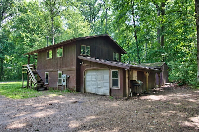 23627 Glenwood Rd, Cassopolis, MI 49031 - view of property exterior with stairs, driveway, a view of trees, and a garage