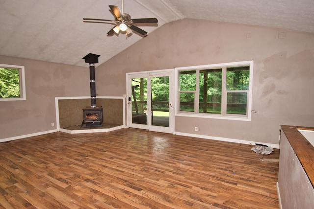 23627 Glenwood Rd, Cassopolis, MI 49031 - unfurnished living room featuring a wood stove, healthy amount of natural light, wood finished floors, and high vaulted ceiling