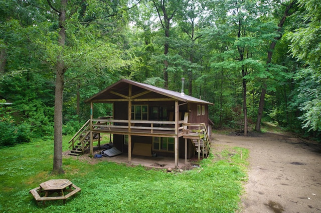 23627 Glenwood Rd, Cassopolis, MI 49031 - back of house featuring stairs, a wooded view, a deck, dirt driveway, and a lawn