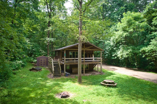 23627 Glenwood Rd, Cassopolis, MI 49031 - rear view of property featuring a fire pit, a wooden deck, a storage shed, and stairs