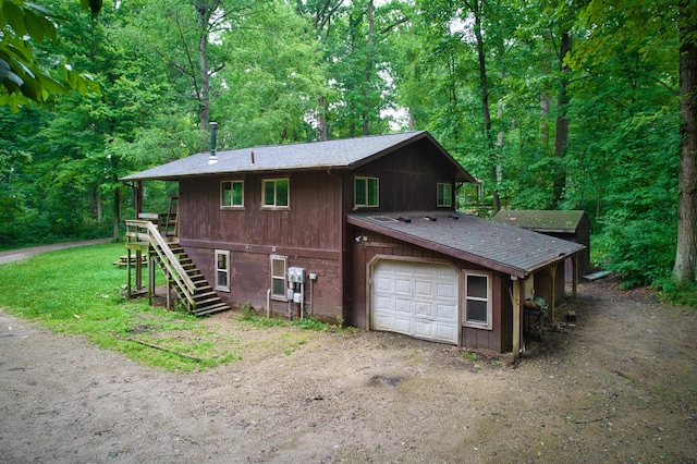 23627 Glenwood Rd, Cassopolis, MI 49031 - view of front of property with stairs, a shingled roof, a wooded view, and a garage