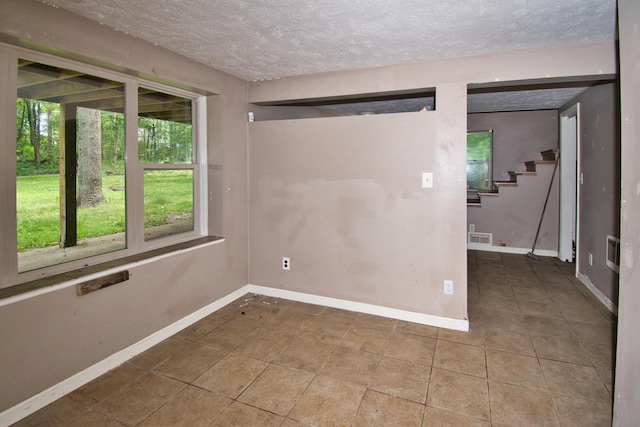 23627 Glenwood Rd, Cassopolis, MI 49031 - tiled empty room featuring a textured ceiling and baseboards