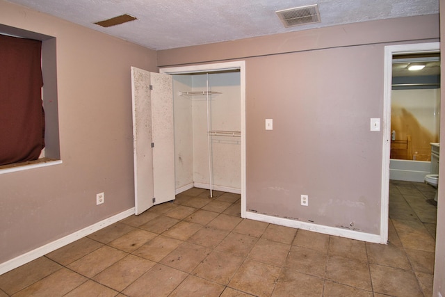 23627 Glenwood Rd, Cassopolis, MI 49031 - unfurnished bedroom featuring a textured ceiling, tile patterned flooring, and a closet