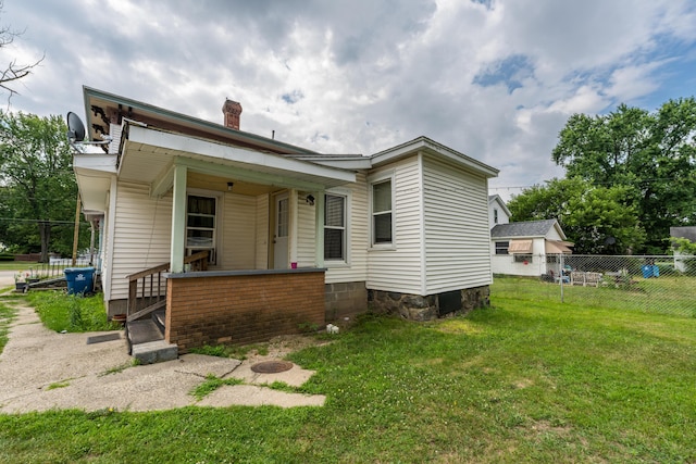 back of property with a chimney and a porch