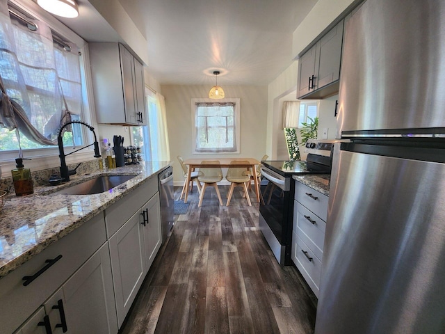 2464 Greenfield Rd, Berkley, MI 48072 - kitchen featuring appliances with stainless steel finishes, dark wood-style flooring, light stone counters, and hanging light fixtures