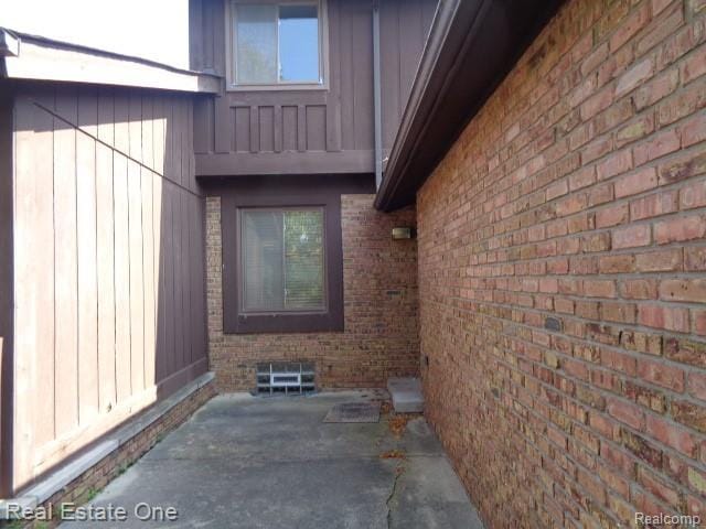 26537 Summerdale Dr, Southfield, MI 48033 - entrance to property with brick siding, a patio area, and board and batten siding