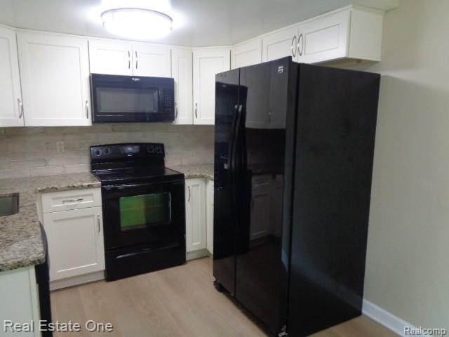 26537 Summerdale Dr, Southfield, MI 48033 - kitchen featuring black appliances, white cabinets, backsplash, light wood-style flooring, and light stone counters