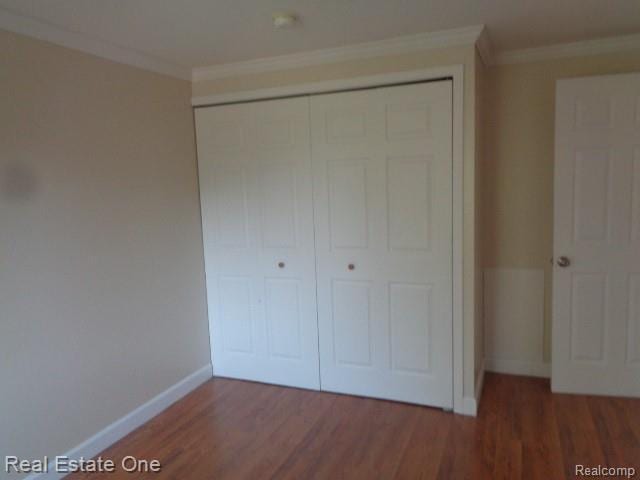 26537 Summerdale Dr, Southfield, MI 48033 - unfurnished bedroom featuring a closet, wood finished floors, and crown molding