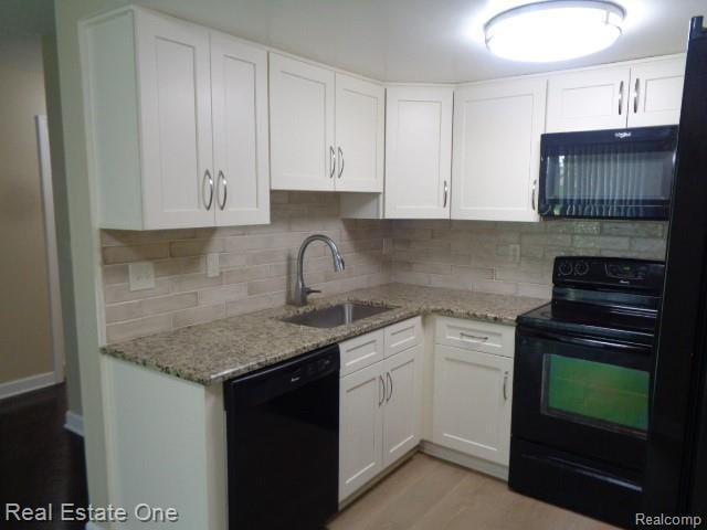 26537 Summerdale Dr, Southfield, MI 48033 - kitchen featuring black appliances, tasteful backsplash, white cabinetry, and light stone counters