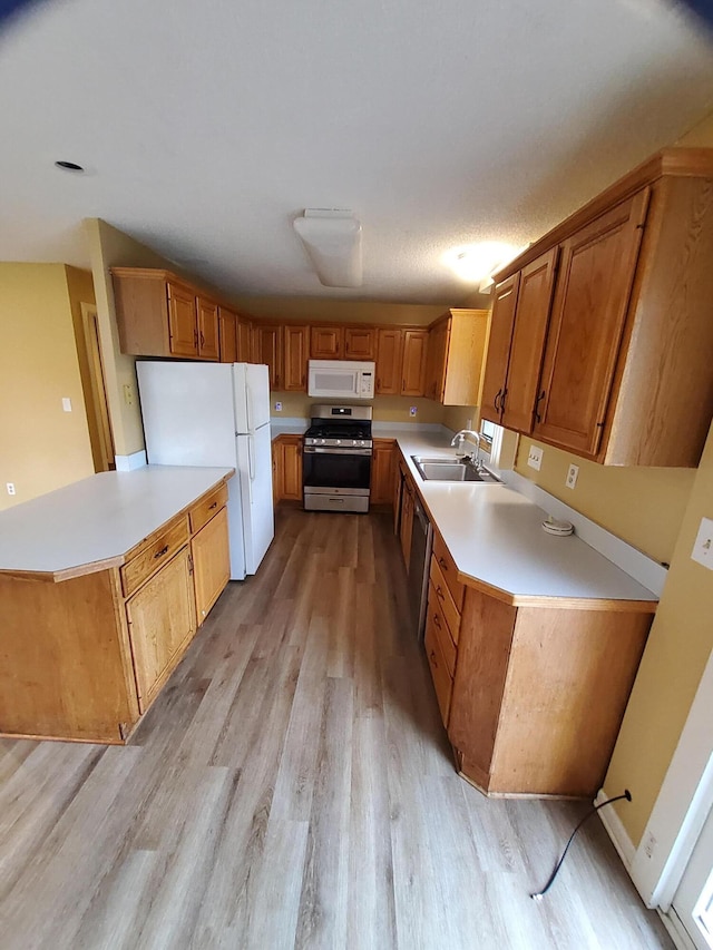 2828 Packard St, Ann Arbor, MI 48108 - kitchen featuring appliances with stainless steel finishes, light wood-style floors, light countertops, and a peninsula