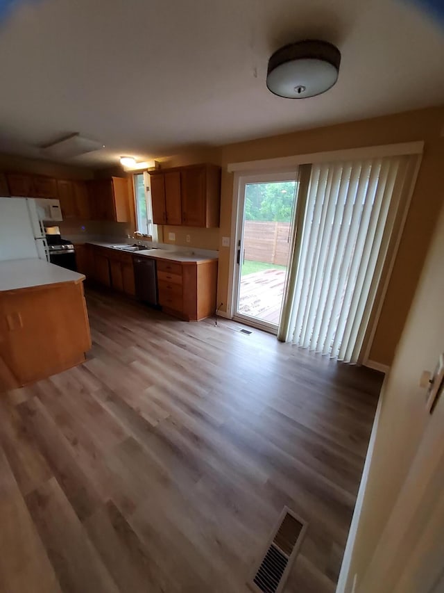 2828 Packard St, Ann Arbor, MI 48108 - kitchen featuring freestanding refrigerator, dishwasher, light wood-style floors, light countertops, and brown cabinets