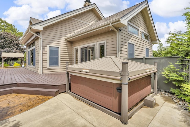 12500 Round Lake Rd, Horton, MI 49246 - deck featuring a hot tub, a patio area, and a garage