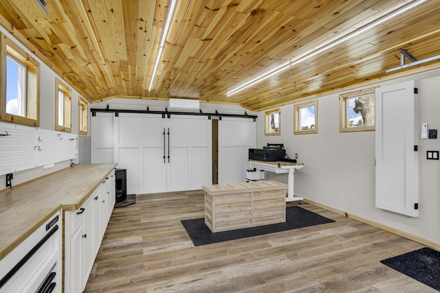12500 Round Lake Rd, Horton, MI 49246 - kitchen featuring a barn door, light wood-style floors, white cabinets, wood counters, and wine cooler