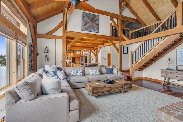 12500 Round Lake Rd, Horton, MI 49246 - living area featuring high vaulted ceiling, stairway, wood finished floors, beamed ceiling, and a chandelier