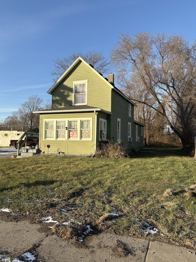 1069 E Main St, Benton Harbor, MI 49022 - view of side of property with a chimney and a lawn