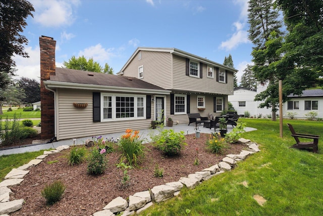 539 Old Bridge Rd, Grand Blanc, MI 48439 - rear view of house featuring a chimney, a patio area, a yard, and a shingled roof