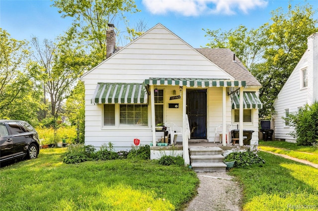 18995 Fielding St, Detroit, MI 48219 - bungalow-style home featuring a chimney, roof with shingles, and a front yard