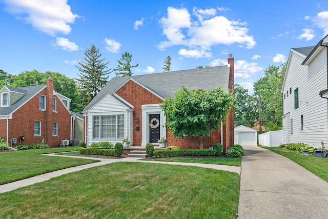 2213 N Wilson Ave, Royal Oak, MI 48073 - view of front of house featuring brick siding, an outbuilding, a front lawn, a detached garage, and a chimney