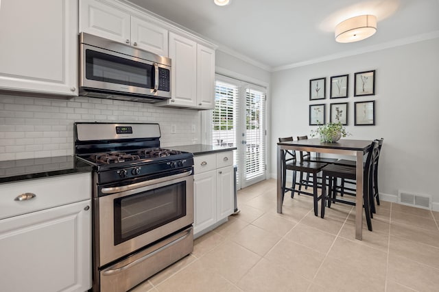 2213 N Wilson Ave, Royal Oak, MI 48073 - kitchen with appliances with stainless steel finishes, crown molding, decorative backsplash, white cabinetry, and light tile patterned floors