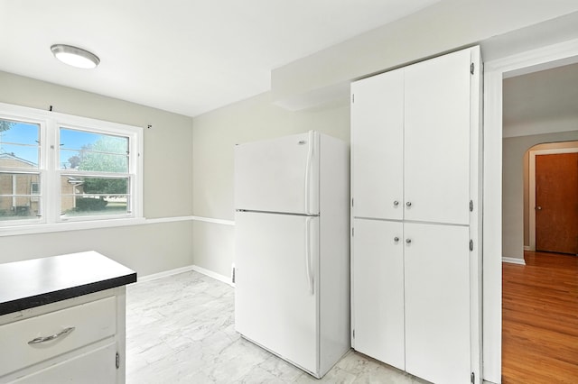 2707 Byron Center Ave SW, Wyoming, MI 49519 - kitchen featuring freestanding refrigerator, light marble finish floors, and white cabinets