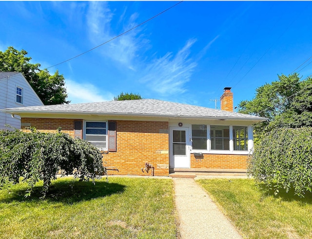 2707 Byron Center Ave SW, Wyoming, MI 49519 - ranch-style house with brick siding, a front lawn, roof with shingles, and a chimney