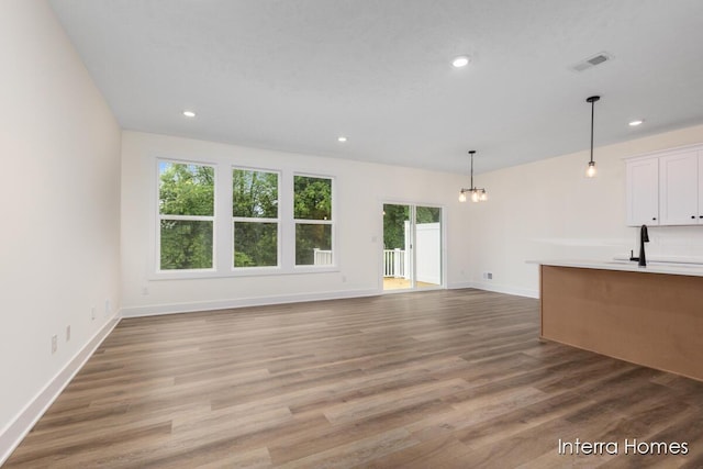 3351 Kings River St SW Unit 35, Wyoming, MI 49418 - unfurnished living room featuring a chandelier, healthy amount of natural light, recessed lighting, and wood finished floors