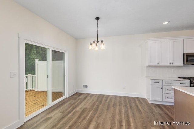 3351 Kings River St SW Unit 35, Wyoming, MI 49418 - unfurnished dining area featuring wood finished floors, a chandelier, and recessed lighting
