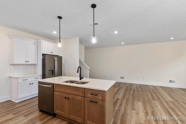 3351 Kings River St SW Unit 35, Wyoming, MI 49418 - kitchen with stainless steel appliances, light wood-type flooring, light countertops, white cabinetry, and an island with sink