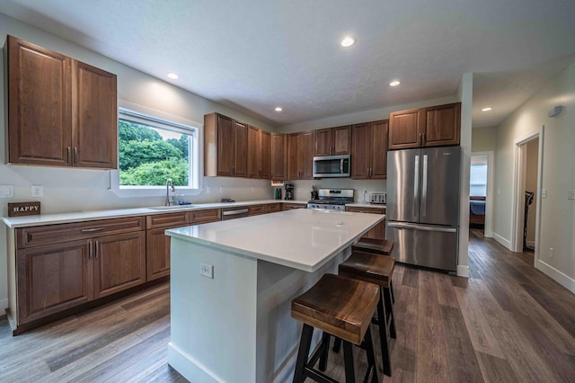 7898 W Juniper Beach Rd, Mears, MI 49436 - kitchen featuring stainless steel appliances, a center island, dark wood finished floors, a kitchen bar, and recessed lighting