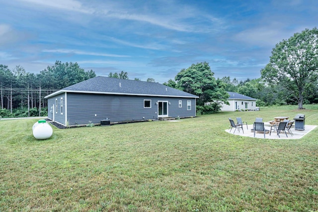 7898 W Juniper Beach Rd, Mears, MI 49436 - back of property with a patio, a lawn, view of scattered trees, and a shingled roof