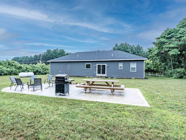 7898 W Juniper Beach Rd, Mears, MI 49436 - back of property featuring a patio area, a lawn, and a shingled roof