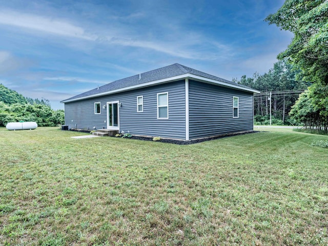 7898 W Juniper Beach Rd, Mears, MI 49436 - rear view of property featuring a lawn and a shingled roof