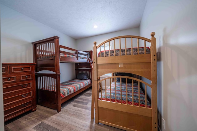 7898 W Juniper Beach Rd, Mears, MI 49436 - bedroom featuring wood finished floors and a textured ceiling