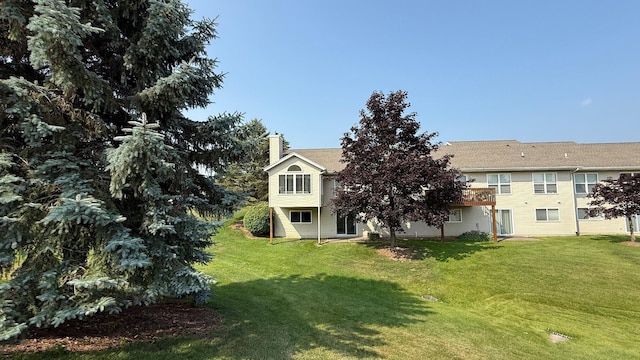 5766 Wineberry Ln SW, Wyoming, MI 49418 - back of house featuring a chimney, a yard, and a wooden deck