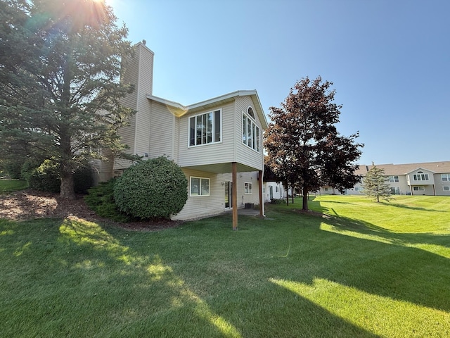 5766 Wineberry Ln SW, Wyoming, MI 49418 - view of side of home with a chimney and a yard