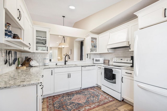 5766 Wineberry Ln SW, Wyoming, MI 49418 - kitchen with white appliances, custom range hood, tasteful backsplash, wood finished floors, and recessed lighting