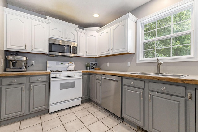 12912 Valley Dr, Wayland, MI 49348 - kitchen featuring gray cabinetry, stainless steel appliances, white cabinets, light tile patterned floors, and recessed lighting