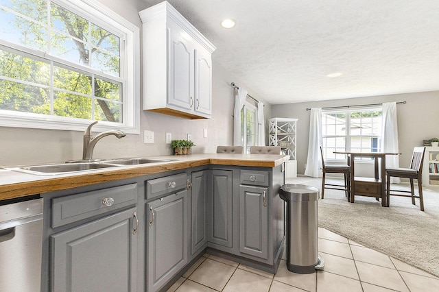 12912 Valley Dr, Wayland, MI 49348 - kitchen featuring gray cabinetry, dishwashing machine, light carpet, white cabinets, and light tile patterned floors